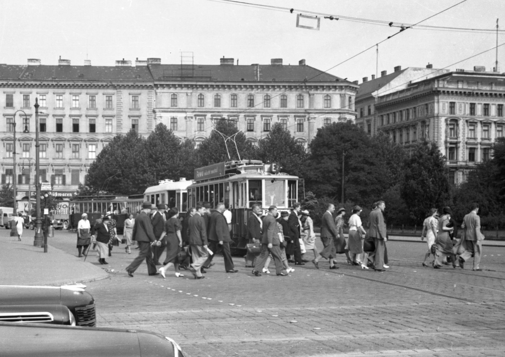 Verkehrssituation am Karlsplatz mit einem Zug der Linie E2 mit Wagen Typen G2-m3 etwa 1952, Personen gehen über Kreuzung