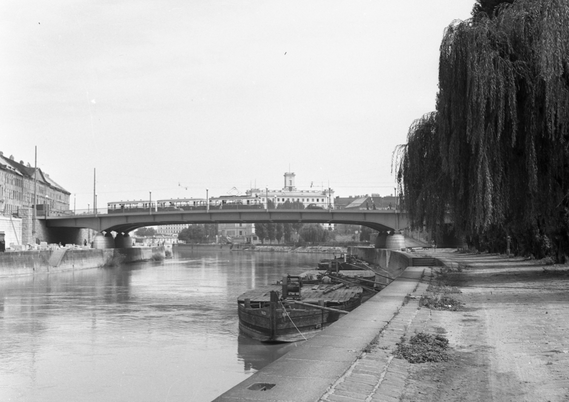 Die Aspernbrücke vom Donaukanal aus gesehen Richtung Süden mit einem Dreiwagenzug der Type B-b-b 1953 im zweiten Bezirk
