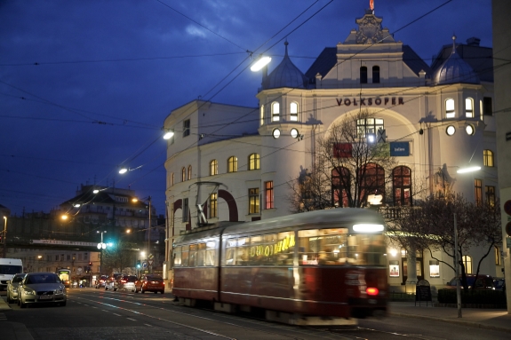 Straßenbahn in der Abenddämmerung vor der Wiener Volksoper.