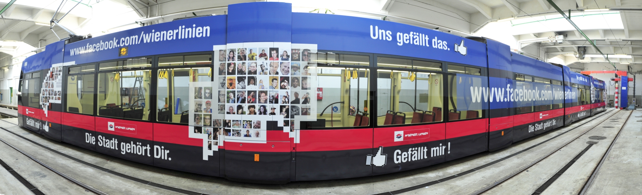 Zwei mit Fotos von Facebook-Freunden der Wiener Linien gestalteten Niederflurstraßenbahn - ULF - werden beklebt.