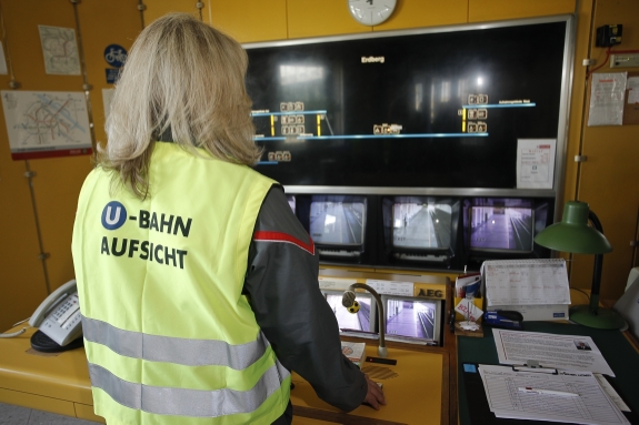 U-Bahn-Aufsicht vor den Kontrollmonitoren in der Stationsüberwachung.