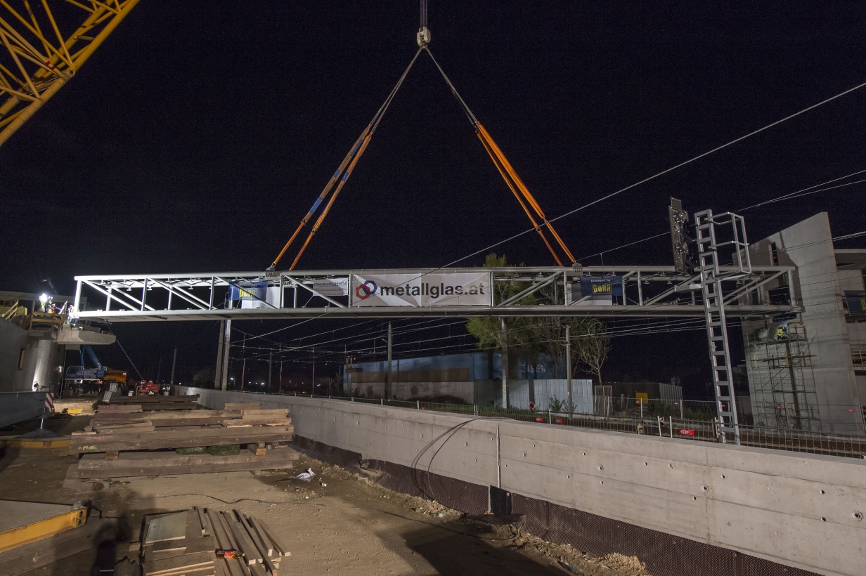 Baustelle der U1-Verlängerung in Oberlaa mit Schwerlastkran. Hebearbeiten von Fußgängersteg über die ÖBB-Gleisanlage werden vorbereitet.