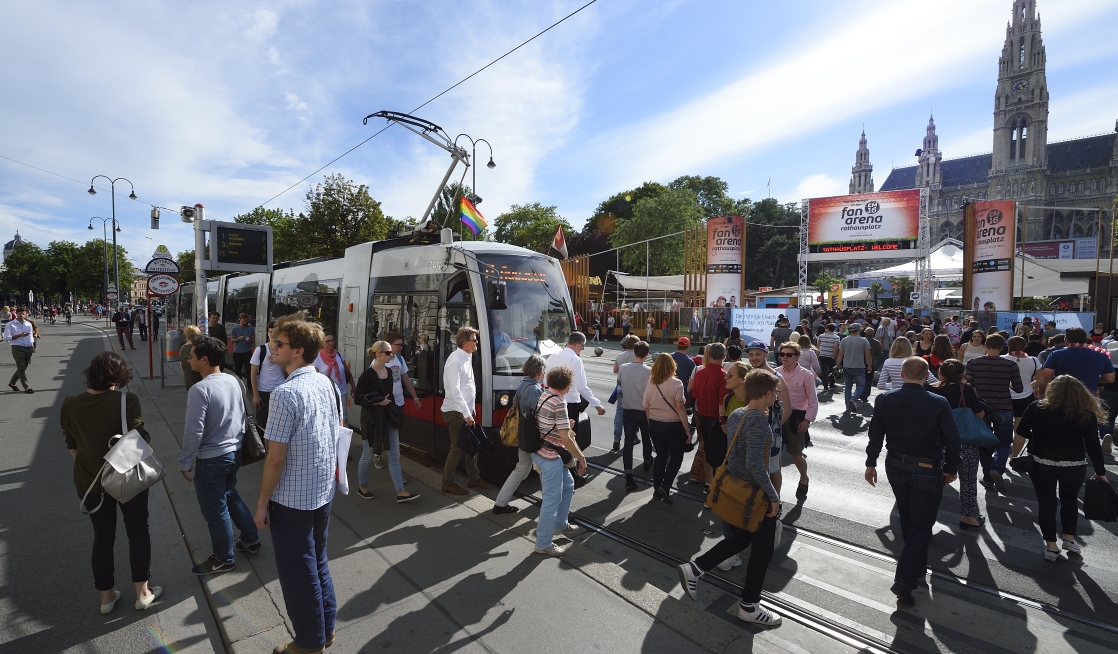 Fußballfans reisen mit der Straßenbahn zum Rathausplatz, der größten Fanarena für 'Public Viewing' in Wien.