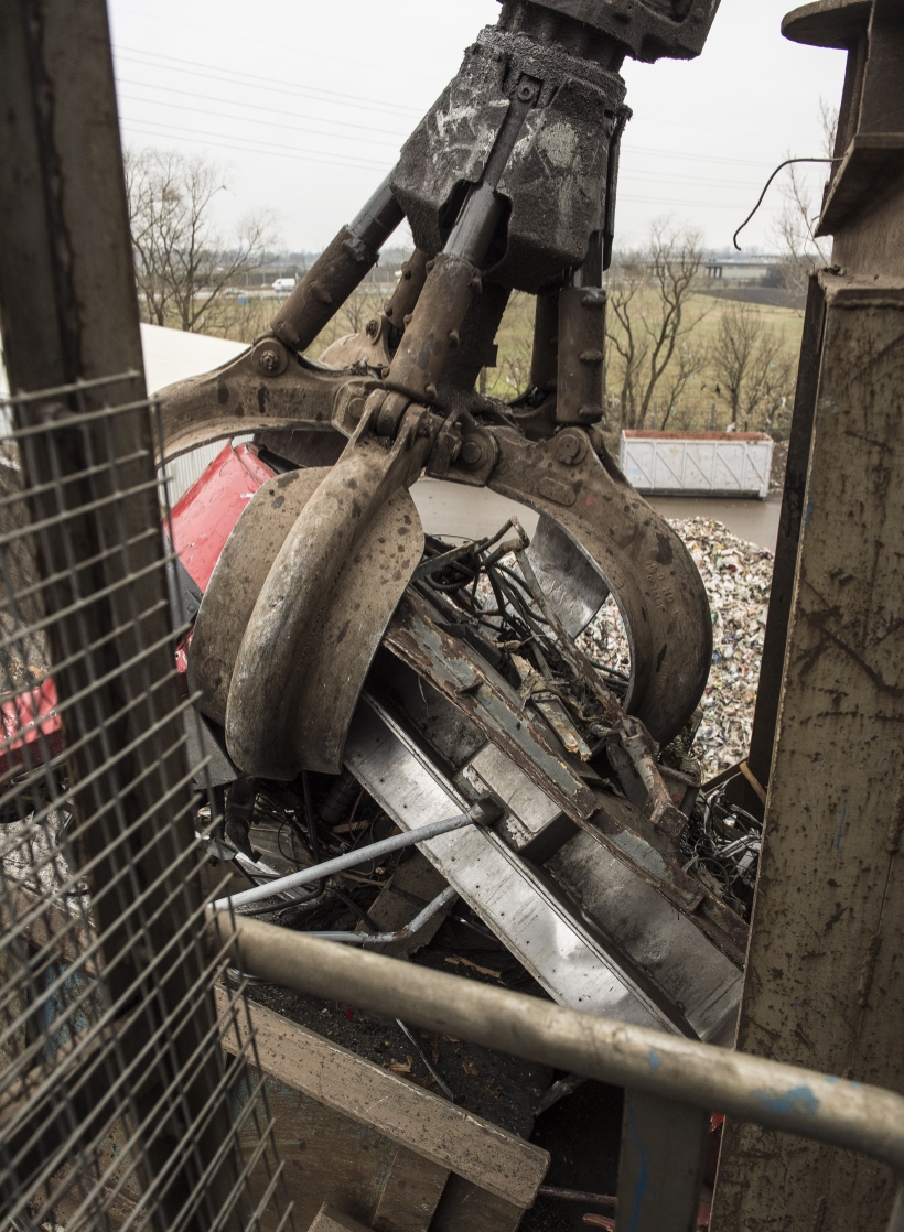 Ausgemusterte Bim wird bei der Firma Scholz in Laxenburg verschrottet. Fahrzeugteile werden in den Schredder gehoben und eingezogen.