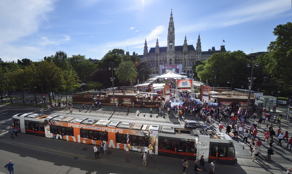 Fußballfans reisen mit der Straßenbahn zum Rathausplatz, der größten Fanarena für 'Public Viewing' in Wien.