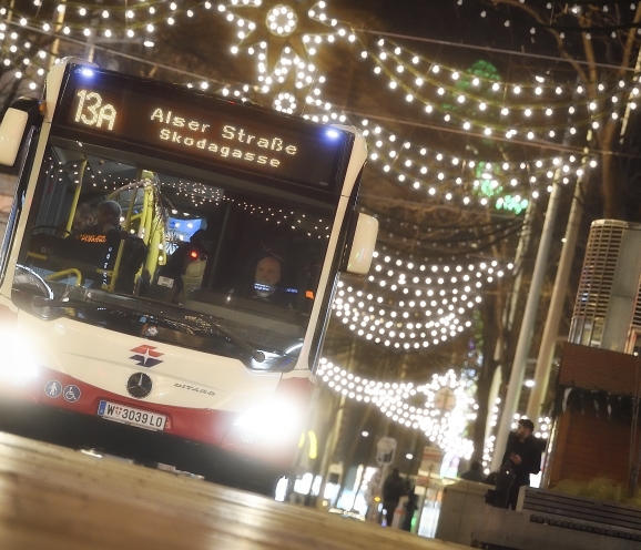 Fahrzeuge der Wiener Linien im weihnachtlich beleuchteten Wien. Hier ein Bus der Linie 13A auf der Mariahilfer Straße.