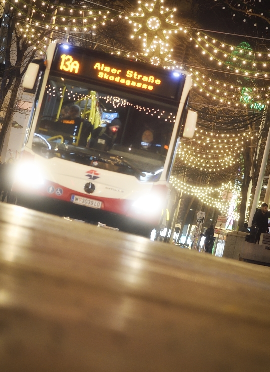 Fahrzeuge der Wiener Linien im weihnachtlich beleuchteten Wien. Hier ein Bus der Linie 13A auf der Mariahilfer Straße.