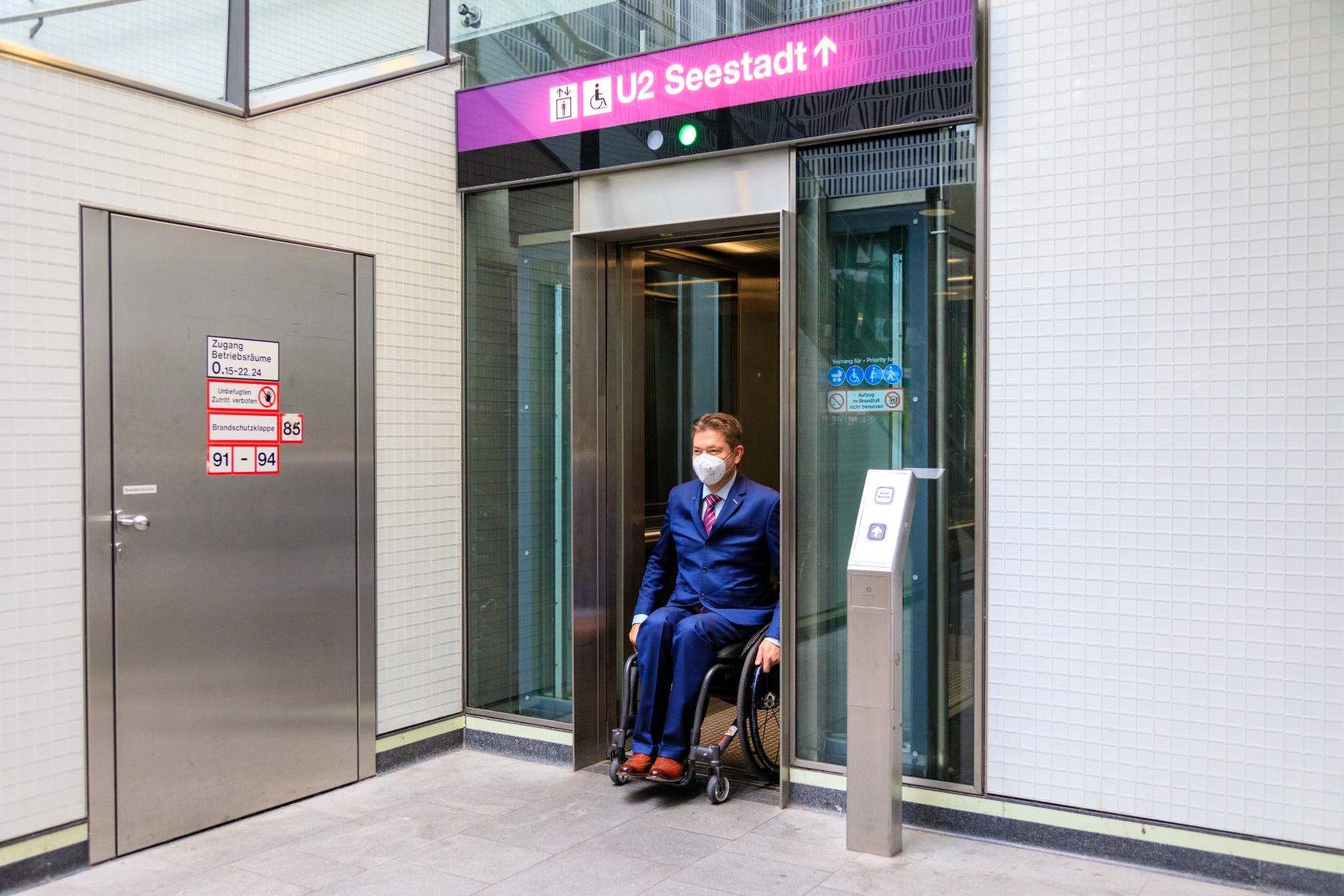 Ein Fahrgast im Rollstuhl steigt aus dem Aufzug einer U-Bahn-Station aus. 