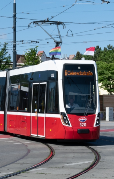Die Linie 6 mit Regenbogenfahnen bei der Absberggasse, Gudrunstraße